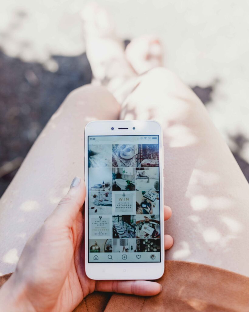 Woman holding a phone while searching for an Instagram account.