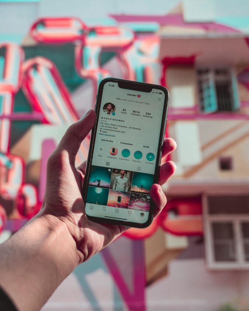 Person holding a smartphone, browsing through someone's profile on Instagram.